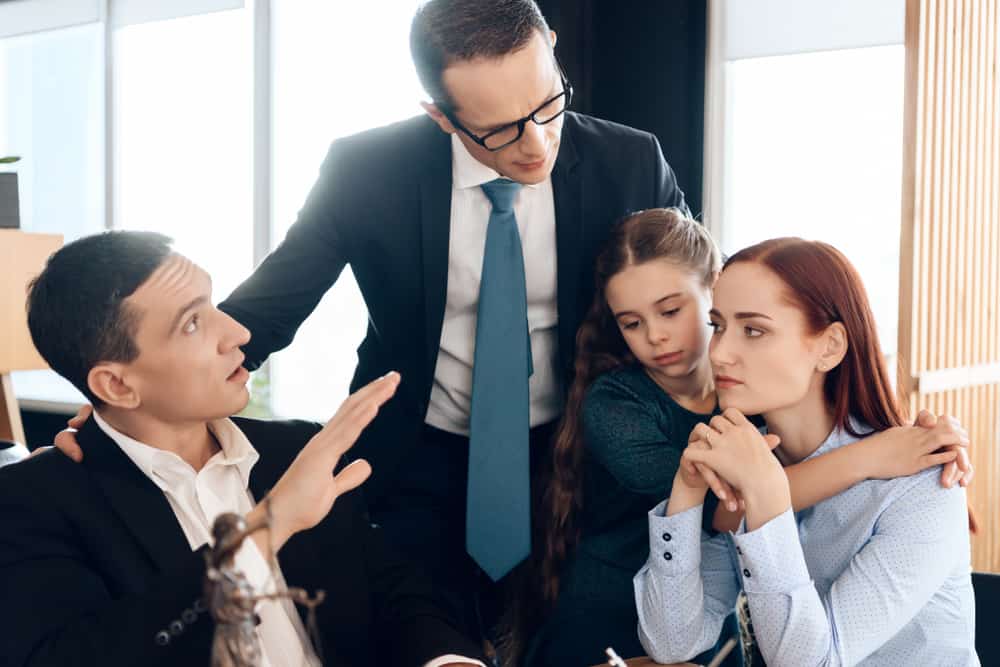 Young family decides who will be guardian of little girl in office of family lawyer. Family in office of family lawyer. Young man and beautiful woman decide who will be main guardian of little girl
